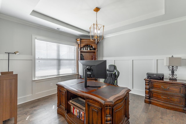 home office featuring visible vents, dark wood finished floors, a chandelier, a decorative wall, and a raised ceiling