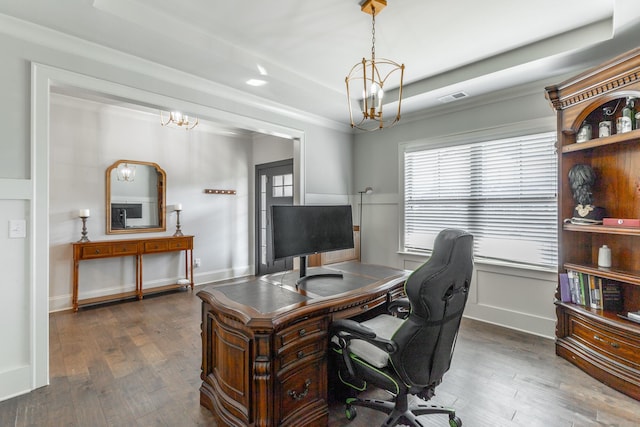 office space featuring hardwood / wood-style floors, a tray ceiling, visible vents, and a chandelier