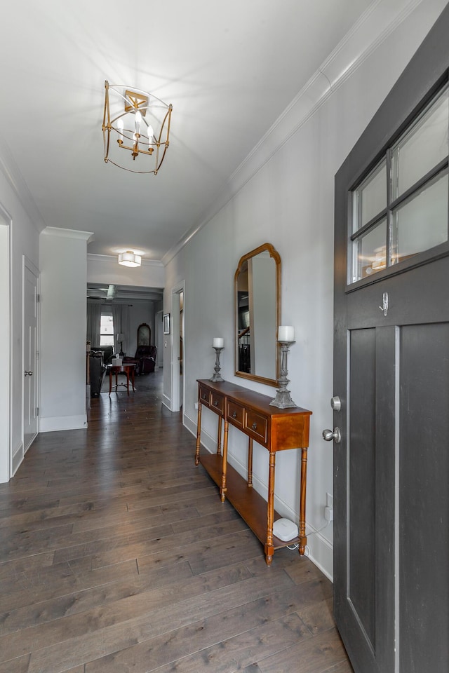 entryway featuring baseboards, crown molding, an inviting chandelier, and wood finished floors