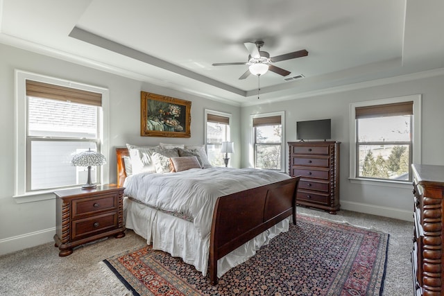 bedroom with visible vents, light colored carpet, baseboards, and a tray ceiling