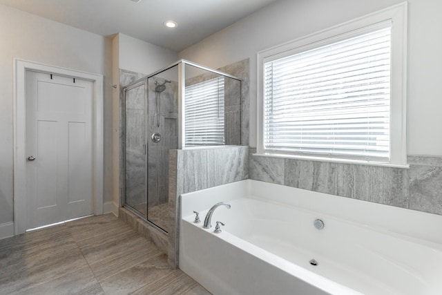 full bathroom featuring a shower stall and a bath