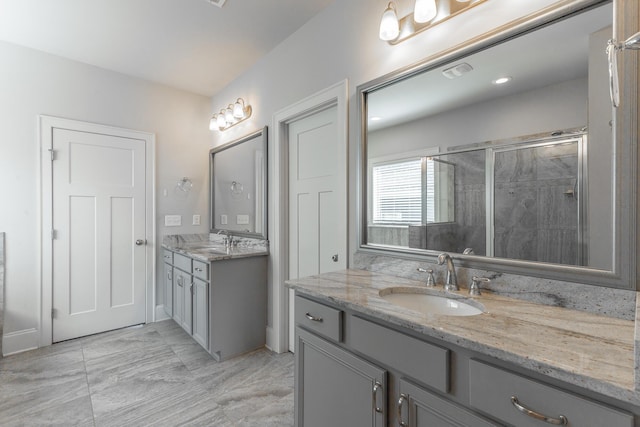 bathroom featuring a shower stall, two vanities, visible vents, and a sink