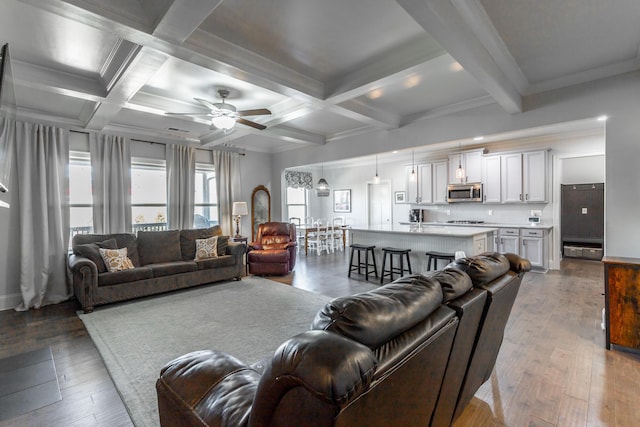 living area featuring beamed ceiling, coffered ceiling, a ceiling fan, and wood-type flooring