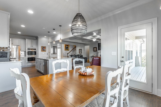 dining area with dark wood-style floors, recessed lighting, a healthy amount of sunlight, and stairs