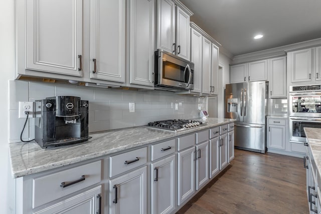 kitchen featuring light stone counters, recessed lighting, dark wood-type flooring, appliances with stainless steel finishes, and tasteful backsplash