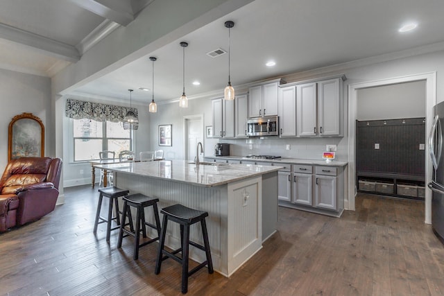 kitchen with a sink, visible vents, appliances with stainless steel finishes, and ornamental molding