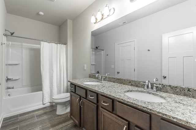 bathroom featuring wood finish floors, visible vents, shower / tub combo with curtain, and a sink