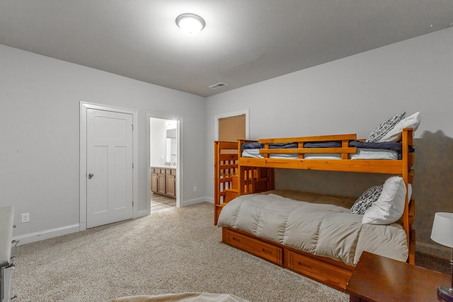 carpeted bedroom with baseboards, visible vents, and ensuite bathroom