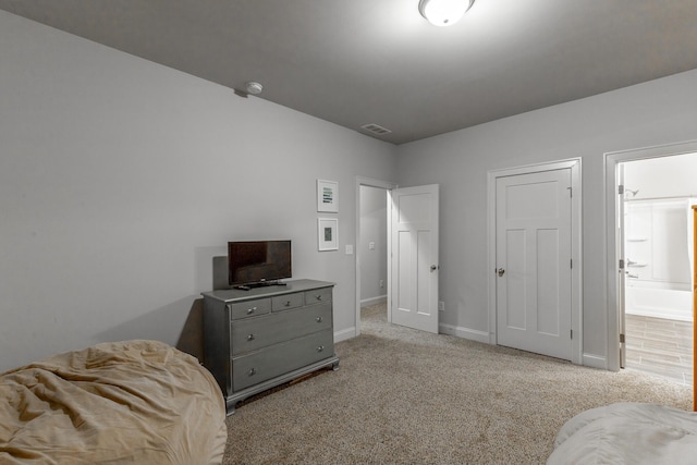 bedroom with visible vents, connected bathroom, baseboards, and carpet floors