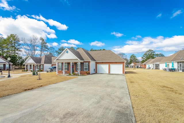 view of front of home featuring brick siding, an attached garage, driveway, and a front lawn