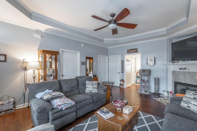 living room featuring a fireplace, wood finished floors, a ceiling fan, baseboards, and ornamental molding