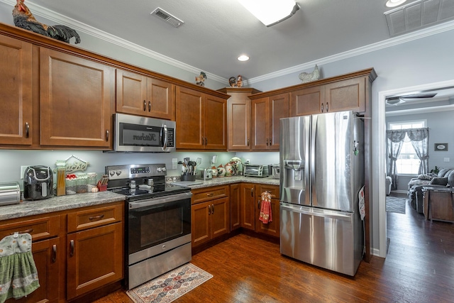 kitchen with appliances with stainless steel finishes, visible vents, and brown cabinets