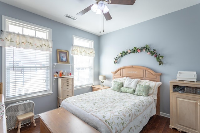 bedroom with baseboards, ceiling fan, visible vents, and dark wood-style flooring