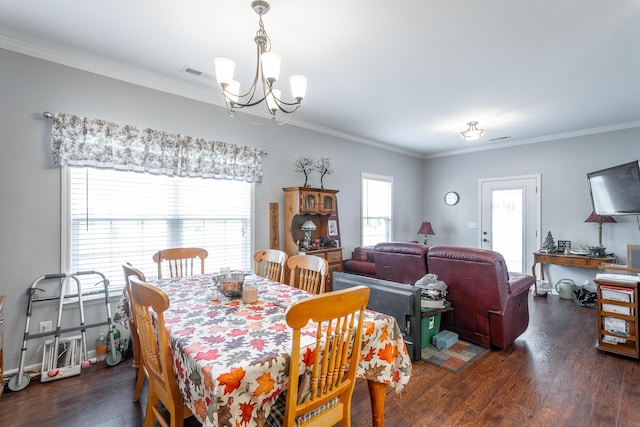 dining area with visible vents, a chandelier, wood finished floors, and ornamental molding