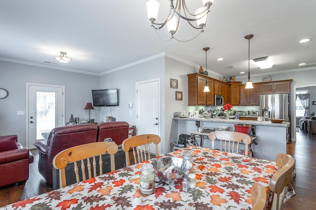 dining area with dark wood-type flooring, recessed lighting, crown molding, and an inviting chandelier