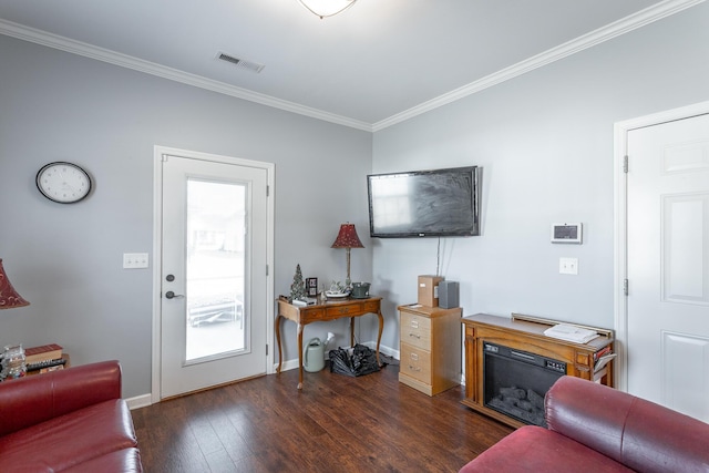 living room with visible vents, crown molding, baseboards, and wood finished floors