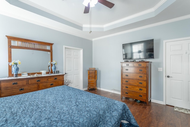 bedroom featuring dark wood-style flooring, a raised ceiling, ornamental molding, a ceiling fan, and baseboards