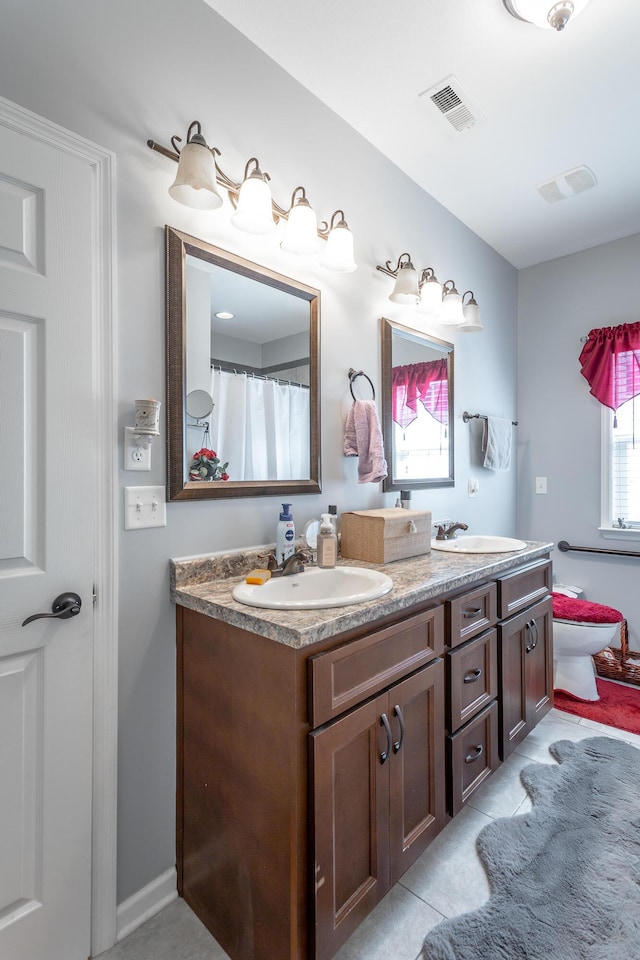 full bath featuring double vanity, visible vents, and a sink