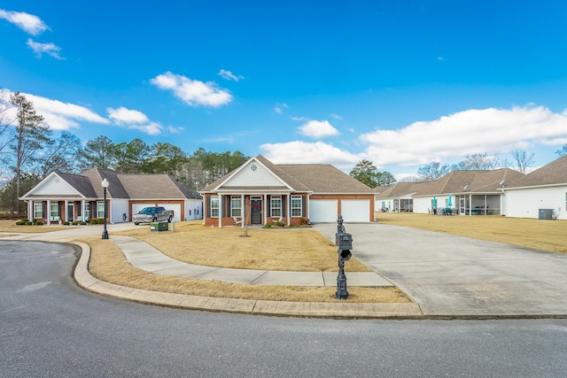 view of front of house with a garage, driveway, central AC unit, and a front yard