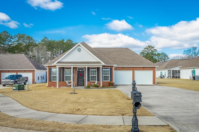 view of front of home with a garage, driveway, a front lawn, and brick siding