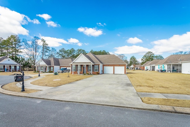 view of front of property featuring a garage, driveway, a front lawn, and a residential view