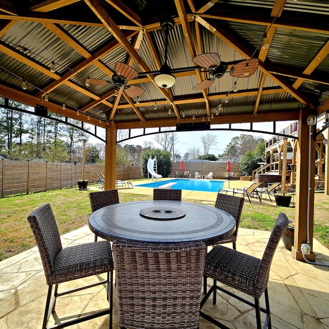 view of patio / terrace featuring outdoor dining space, a fenced backyard, a fenced in pool, and a gazebo