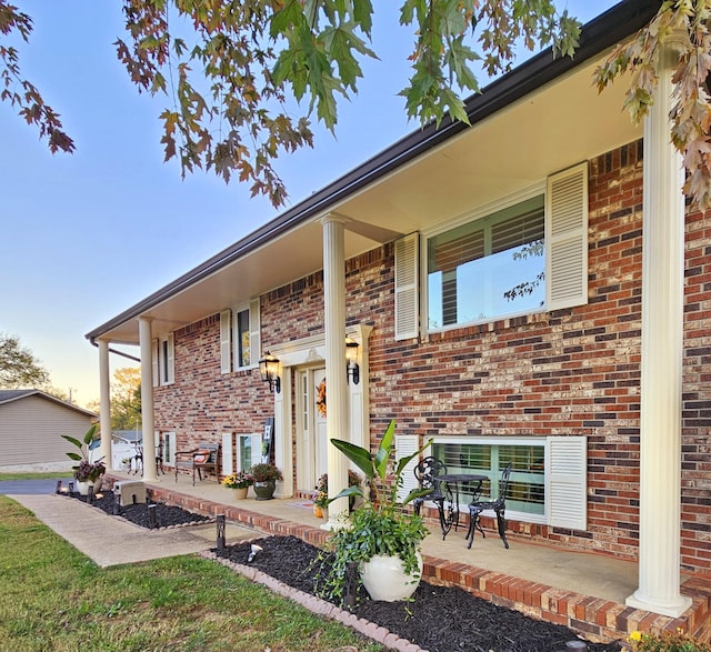 view of front of house with covered porch and brick siding