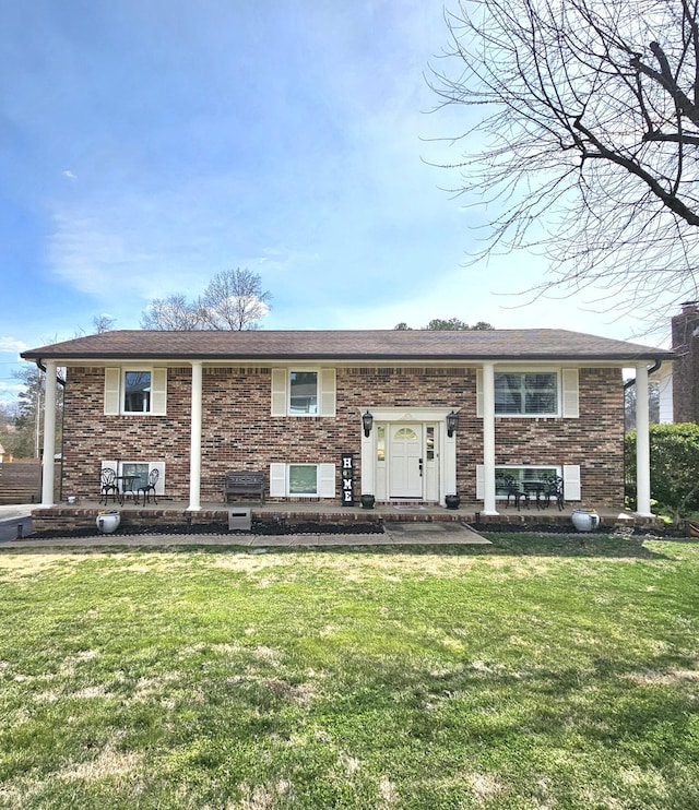 bi-level home with brick siding and a front lawn