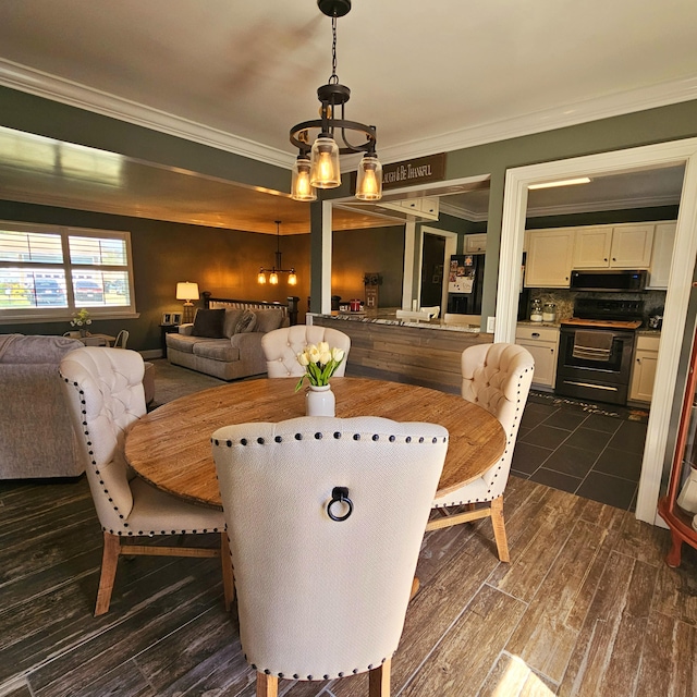 dining area featuring a notable chandelier, dark wood finished floors, and crown molding