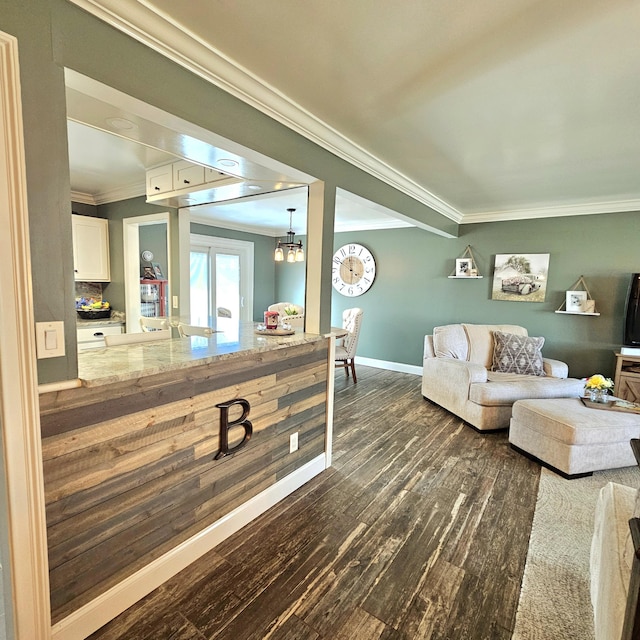 interior space with baseboards, dark wood finished floors, ornamental molding, an inviting chandelier, and french doors