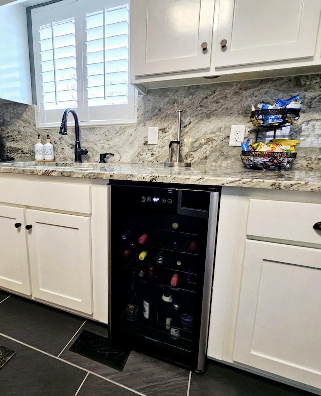 bar with beverage cooler, a sink, backsplash, and dark tile patterned floors