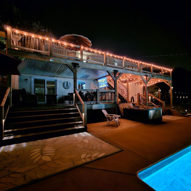 patio at night with stairs and a deck