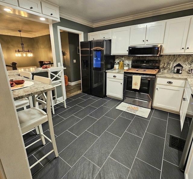 kitchen with tasteful backsplash, appliances with stainless steel finishes, white cabinets, and crown molding