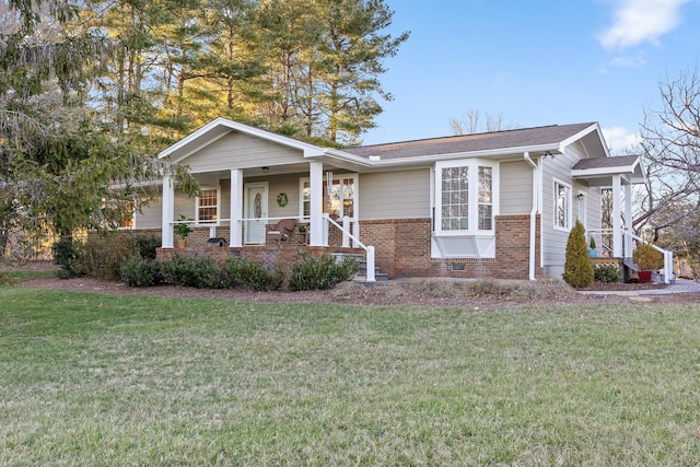 view of front of house with a porch, brick siding, and a front lawn