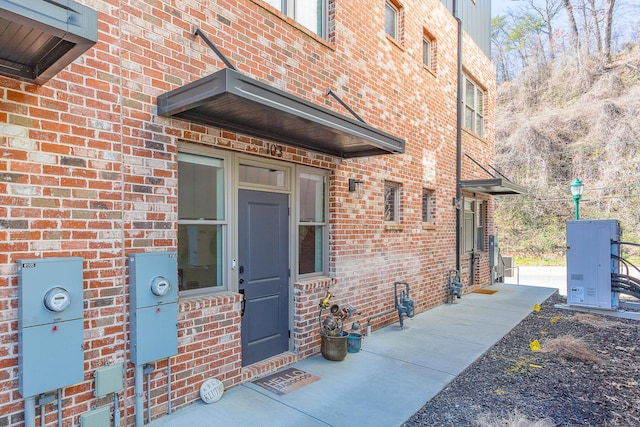 doorway to property featuring brick siding