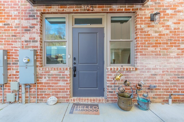 view of exterior entry featuring brick siding