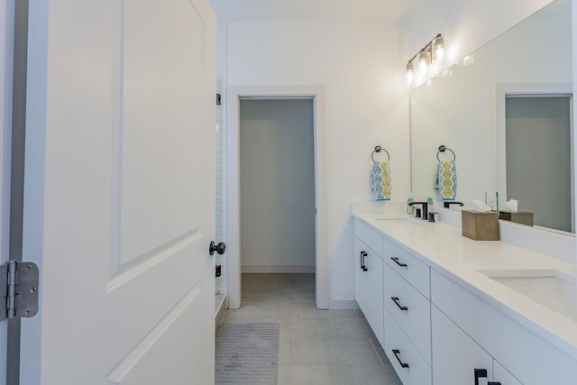 bathroom featuring double vanity, walk in shower, tile patterned flooring, and a sink