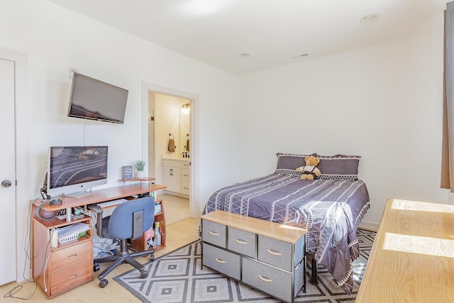 bedroom with light wood-style floors and ensuite bathroom