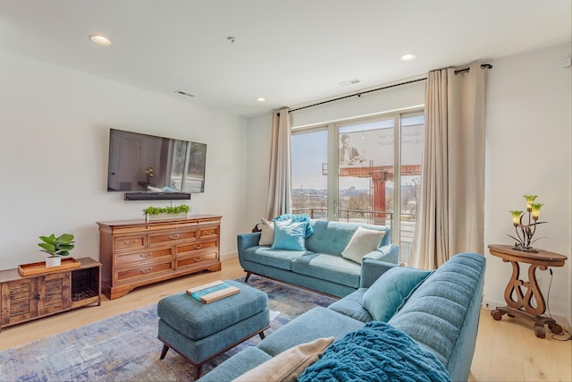 living area featuring recessed lighting, baseboards, visible vents, and light wood finished floors