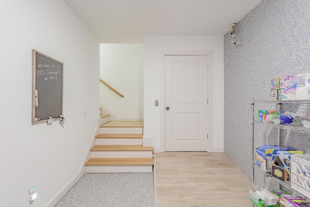 stairs with wood finished floors and baseboards