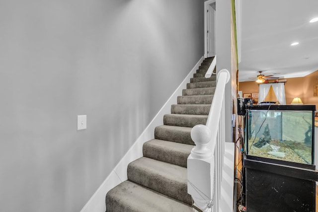 stairway with ceiling fan, baseboards, and recessed lighting