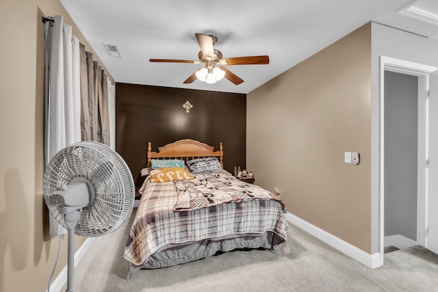 carpeted bedroom featuring a ceiling fan, visible vents, and baseboards