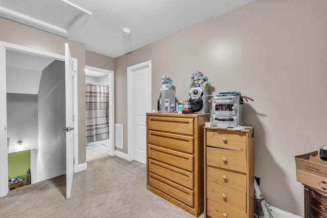 bedroom featuring attic access, light colored carpet, visible vents, and baseboards