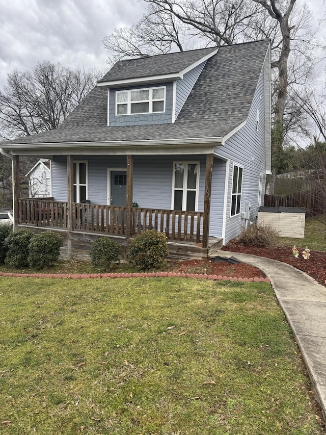 bungalow-style home with a porch, roof with shingles, and a front yard