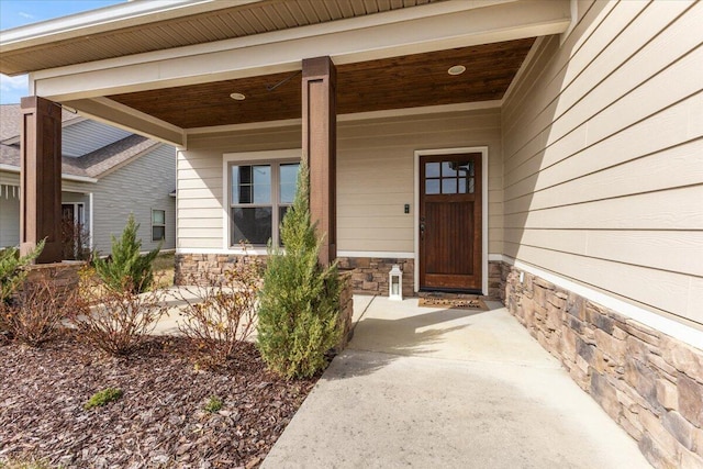 property entrance with stone siding and a porch