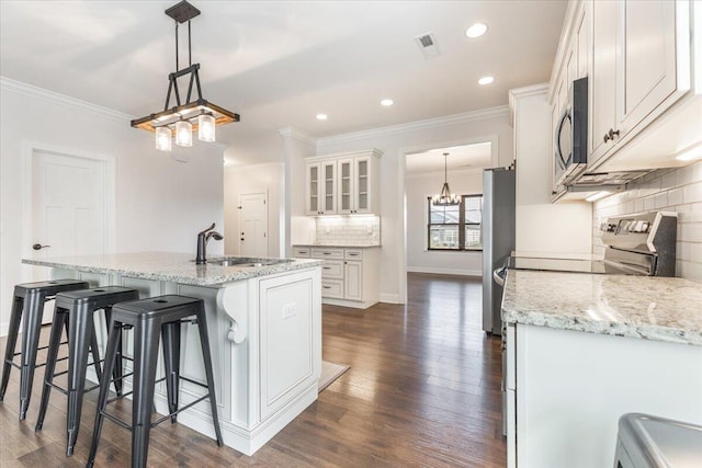 kitchen featuring visible vents, ornamental molding, appliances with stainless steel finishes, and a sink