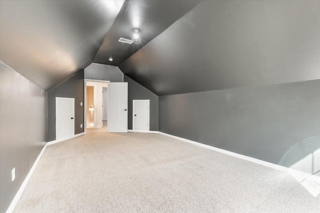 additional living space featuring carpet flooring, visible vents, baseboards, and vaulted ceiling