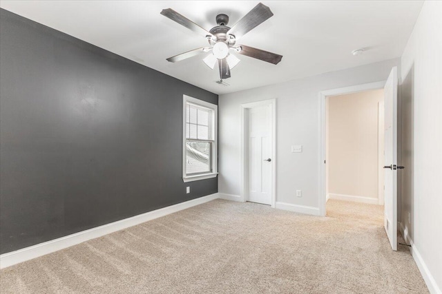 unfurnished bedroom with light carpet, ceiling fan, and baseboards