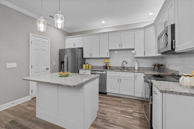 kitchen with ornamental molding, appliances with stainless steel finishes, a sink, and dark wood finished floors