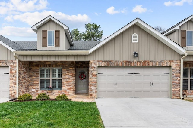 view of front of house with a garage, concrete driveway, roof with shingles, board and batten siding, and a front yard